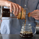 Man pouring cold brew from French press coffee maker